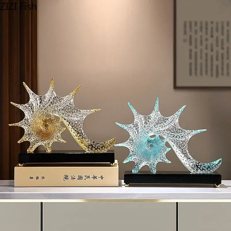 Two decorative glass bubble conch sculptures in gold clear and translucent blue on black bases for bedroom decor