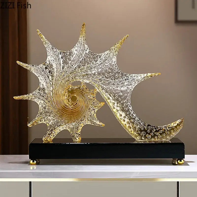 Golden and clear glass bubble conch sculpture with swirling spiral design on black base for bedroom aesthetic decor