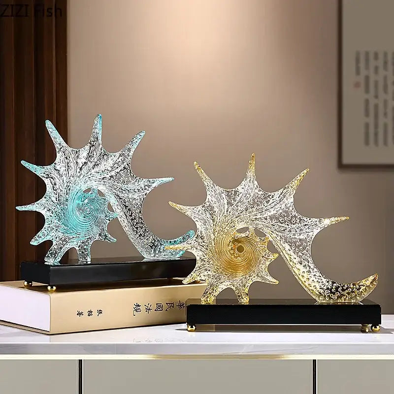 Two translucent glass bubble conch sculptures with turquoise and gold centers on black bases for bedroom decor