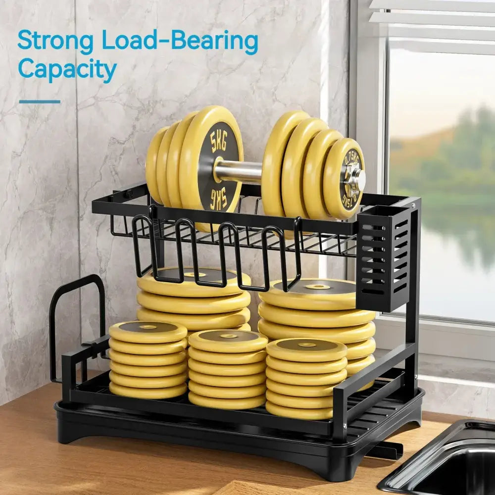Two-tier black metal dish drying rack with drainboard holding yellow weight plates and dumbbells for kitchen organizer