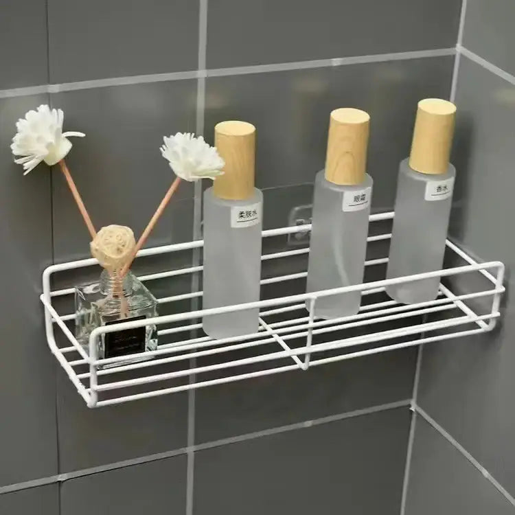 White wire bathroom storage shelves holding frosted glass bottles and reed diffuser for decorbites corner bathroom organization