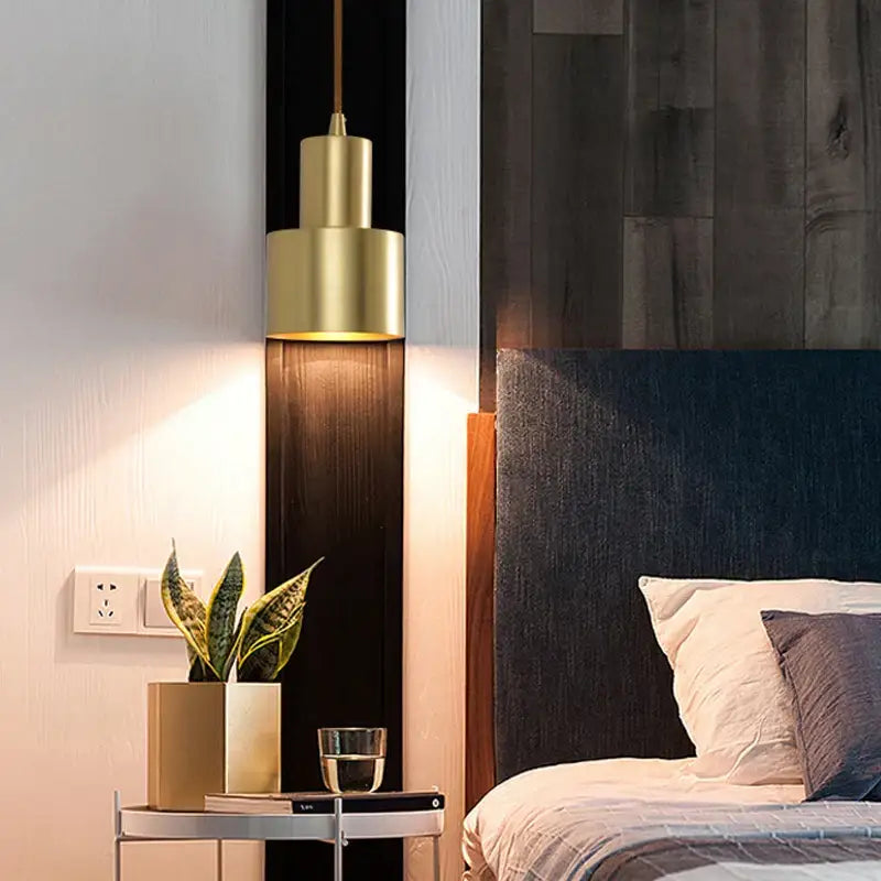 Two tier brass finish pendant light with gold-toned cylindrical design hanging above bedside table decorbites brass finish
