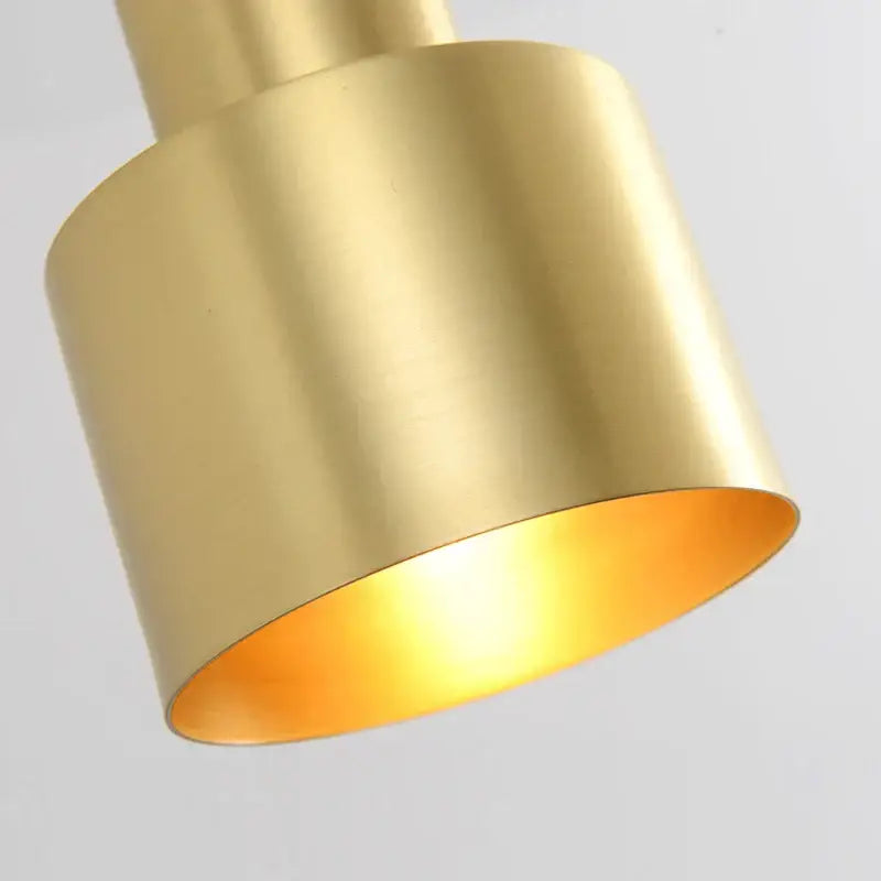 Two tier brass finish pendant light with a sleek cylindrical design and warm golden interior for dining room decorbites brass finish
