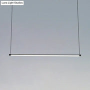 Minimalist black ultra slim tube led office hanging lamp with frosted glass diffuser providing warm white light for dining rooms