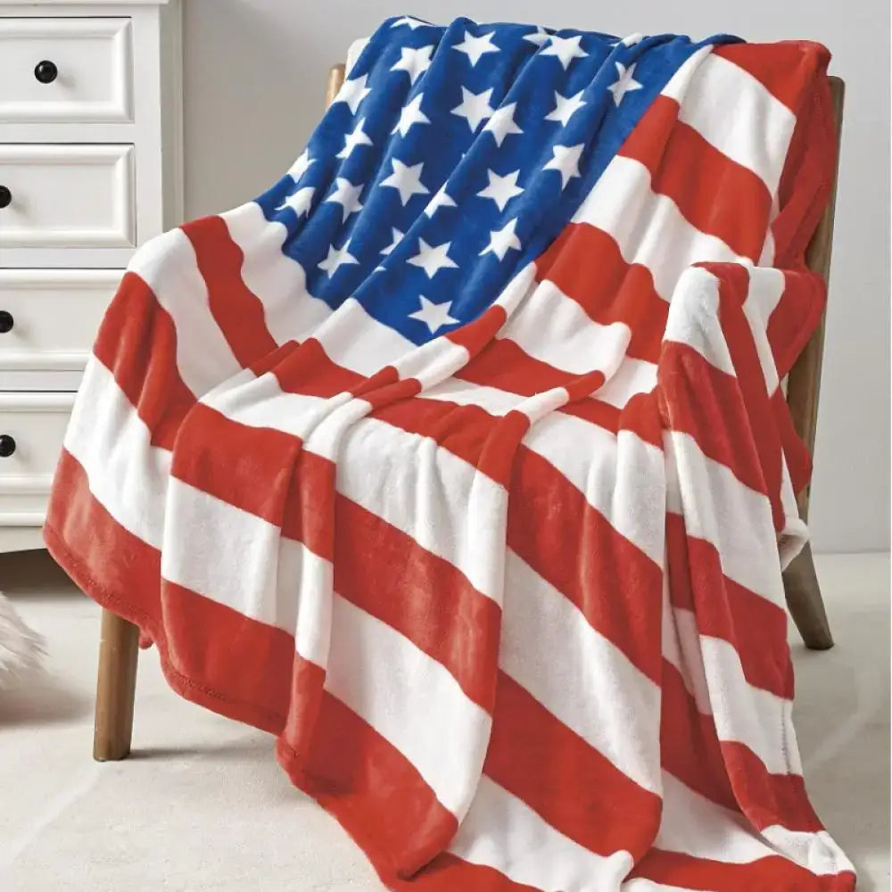 A decorbites cozy flannel throw blanket with union jack red navy stripes and stars draped over a wooden chair