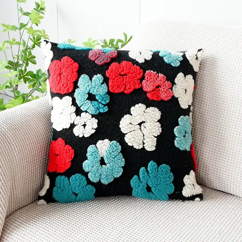 Black pillow case featuring raised fluffy red white and teal floral patterns in decorbites 3d floral jacquard design