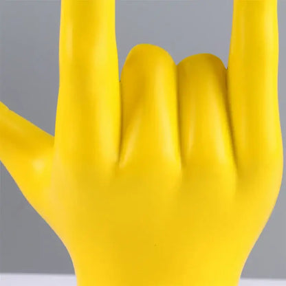Bright yellow glossy plastic decorbites abstract hand love sculpture making a rock gesture for living room decor