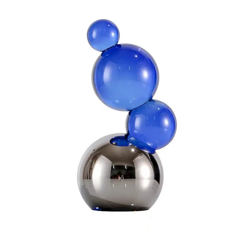 Vibrant glossy blue crystal bubble decor spheres stacked on a reflective silver base for elegant home decor
