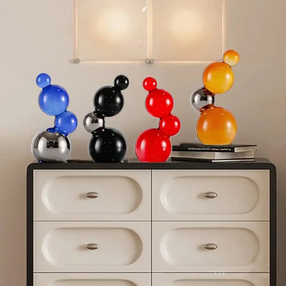 Set of four modern crystal bubble decor spheres in blue black red and orange with reflective metallic bases for home decor