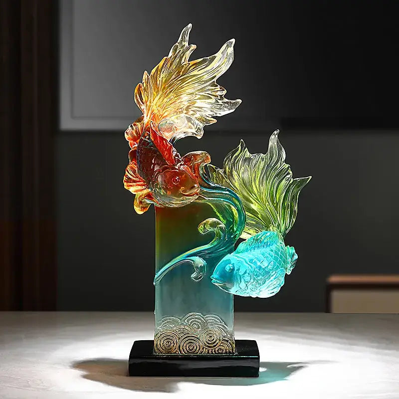 Vibrant gradient goldfish resin sculpture features translucent orange and turquoise goldfish around a golden patterned base for decorbites living room decor