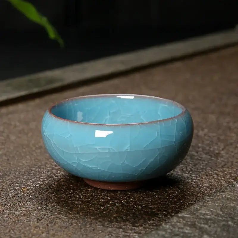 A delicate turquoise ice cracking ceramic tea cup with crackled glaze and earthy brown base for decorbites decor