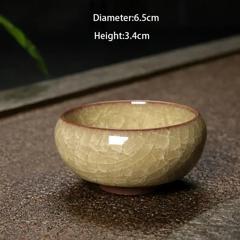 A small round ceramic tea bowl with vibrant ice cracking ceramic glaze in pale green and brown for dining room decorbites decor