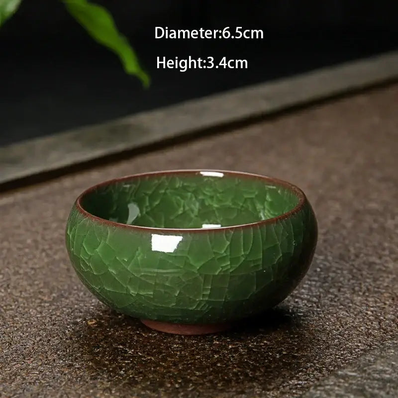 A small deep green ice cracking ceramic tea bowl with crackled glaze and brown rim for decorbites kitchen decor
