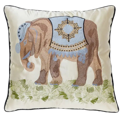 Cream-colored pillow cover with decorbites elephant embroidery in brown and light blue on grassy lime green decor