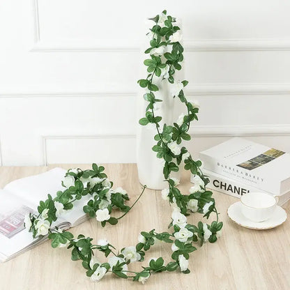A delicate artificial flowers vine garland with white blossoms and green leaves made from synthetic material for decor