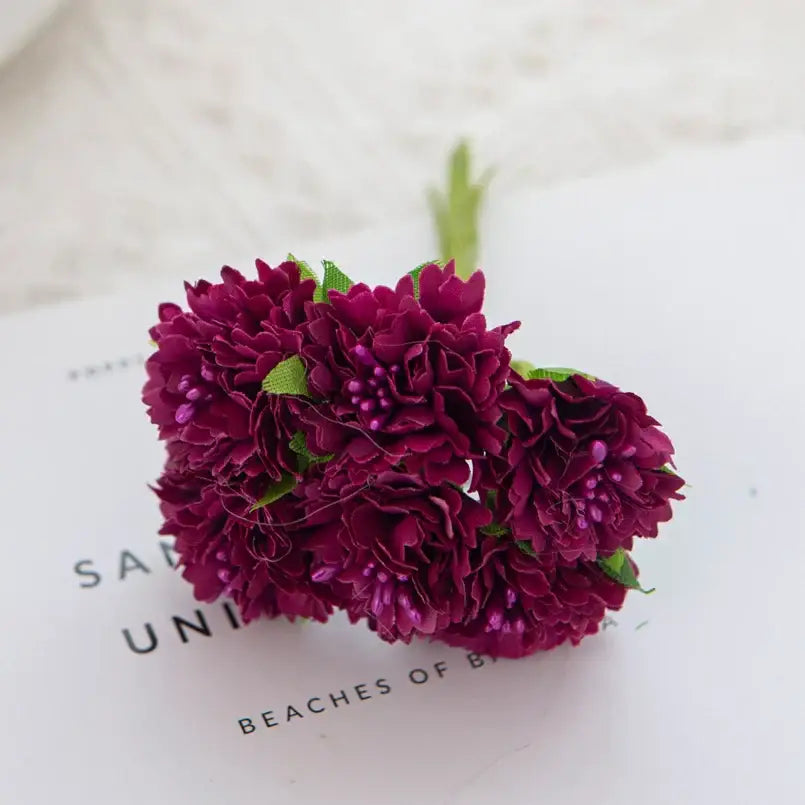 A cluster of deep burgundy silk carnation stamen flowers with green fabric stems perfect for decorbites living room decor