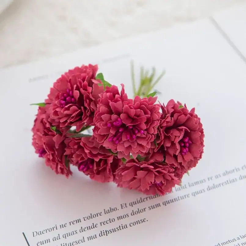 A cluster of deep red decorbites carnation stamen silk flowers with delicate layered petals and small purple centers for living room decor
