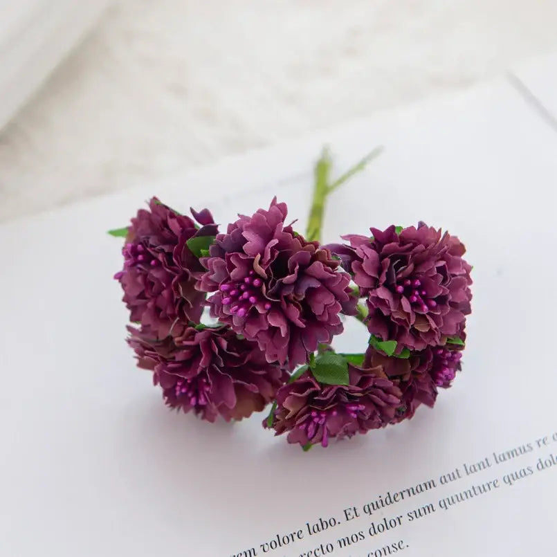 A cluster of deep purple artificial silk flowers with layered petals and green stems decorbites carnation stamen decor