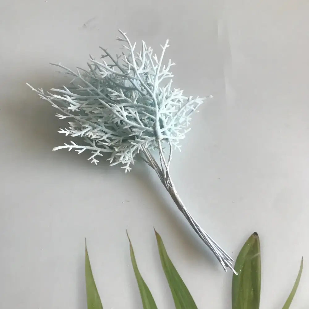 Delicate light blue artificial branch with feathery texture in vibrant multicolored dried flower bouquets in white vase