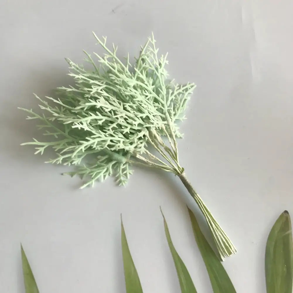Delicate light green artificial dried flower bouquets with feathery foliage in a white vase for living room decor