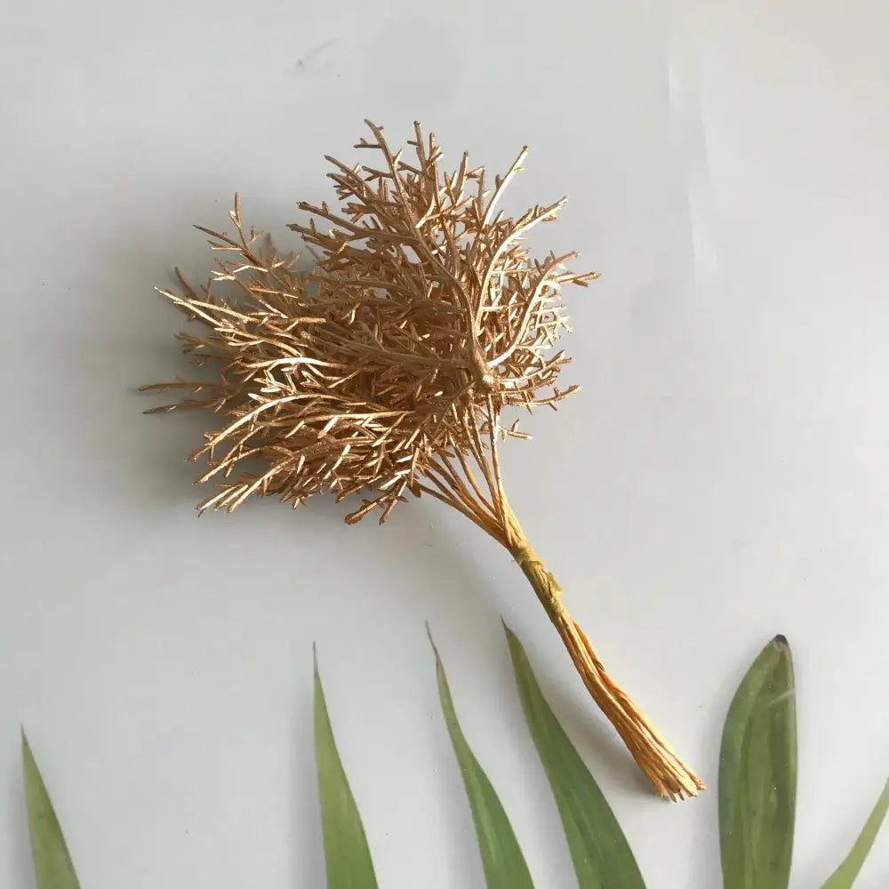 Golden metallic coral branch decoration complementing vibrant multicolored dried flower bouquets in white vase living room