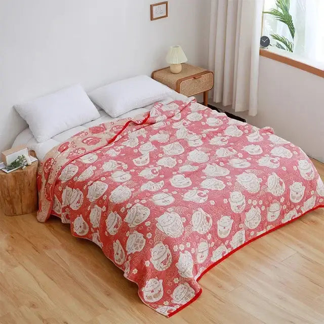 Pink throw blanket with white lucky cat faces and red accents in soft fabric complements nordic throw blanket designs
