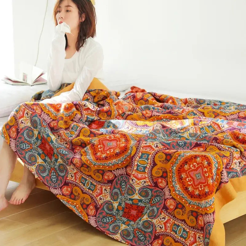 Vibrant orange and red paisley-patterned nordic throw blanket with intricate circular designs for bedroom bedspread