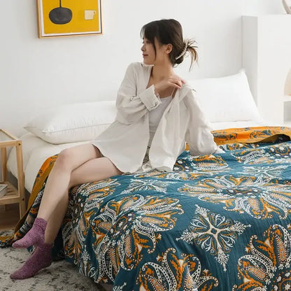 Teal and gold paisley patterned quilt throw blanket complementing a vibrant orange and gold geometric nordic throw blanket design