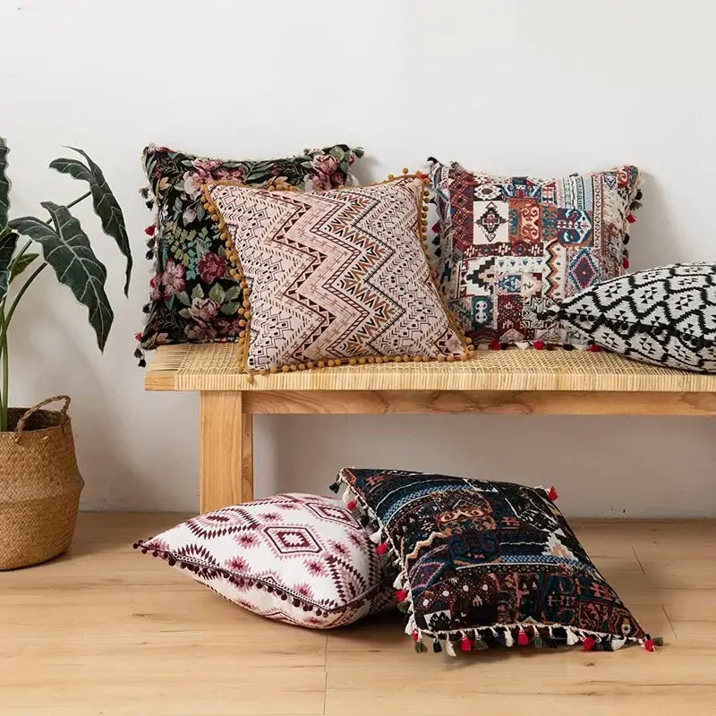 A collection of decorbites ethnic boho throw pillow covers with intricate geometric floral patterns and colorful pom-poms