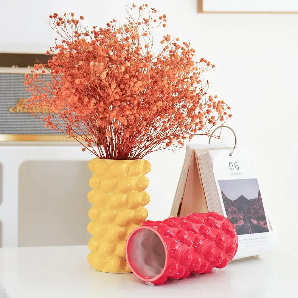 Yellow ceramic fruit relief vase with textured surface holding dried orange flowers for decorbites fruit relief decor