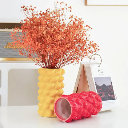 Yellow ceramic fruit relief vase with textured surface holding dried orange flowers for decorbites fruit relief decor