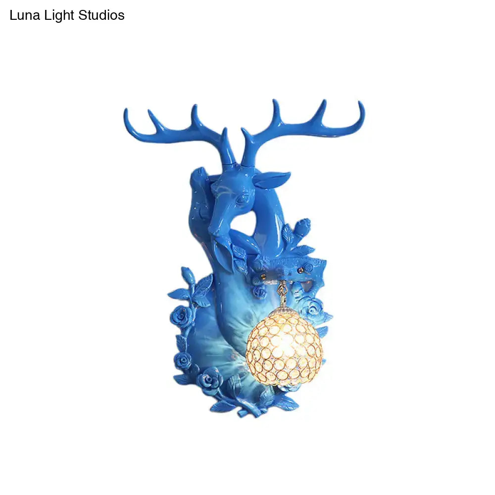 Vibrant blue deer head accent wall sconce with intricate antlers and warm spherical lampshade for bedroom lighting