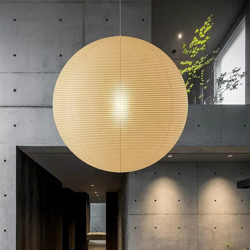 A warm spherical vintage akari rice paper pendant light with horizontal ribbing for bedroom or living room use