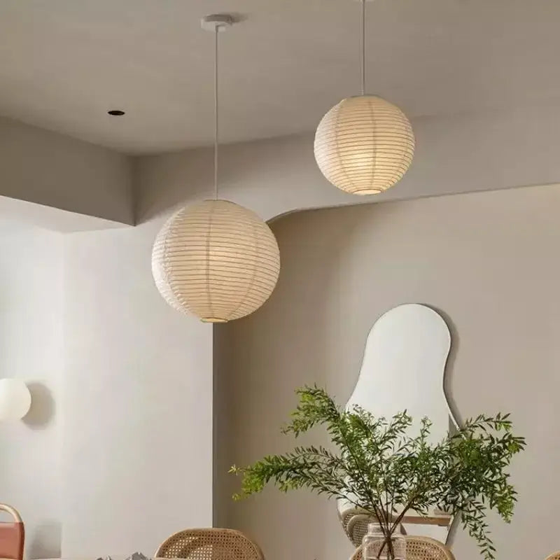 Two off-white vintage akari rice paper pendant lights hang from the ceiling for bedroom or living room use