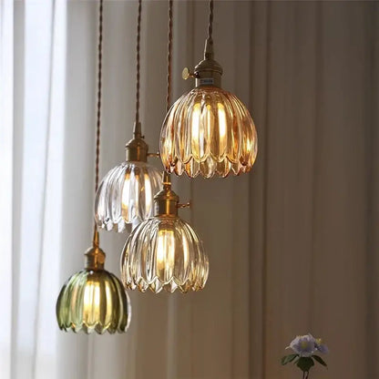 Vintage amber and clear glass pendant light with fluted shades and iron finish suspended by twisted copper cords