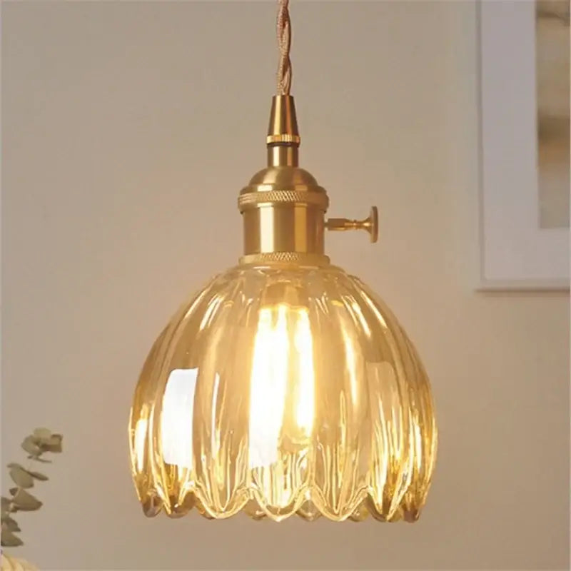 Vintage amber and clear glass pendant light with fluted design, brass hardware, and iron finish for dining room