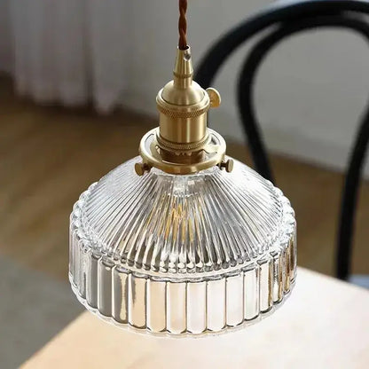 Vintage amber colored glass pendant light with brass fixture and ribbed textured design for dining room use