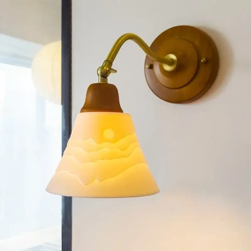 Vintage amber cracked glass led wall lights with carved mountain and sun design mounted on brass and wood sconce
