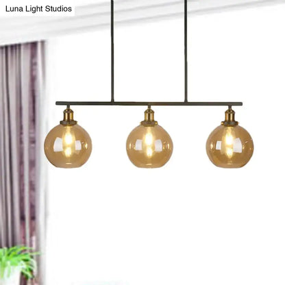 Modern three-light pendant fixture with amber glass globes and brass accents for 220v-240v lighting use