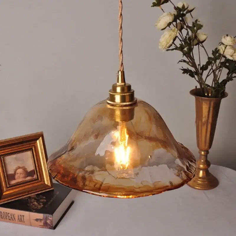 Vintage amber glass adjustable pendant light featuring warm amber hand-blown glass and brass-finished fixture for dining room