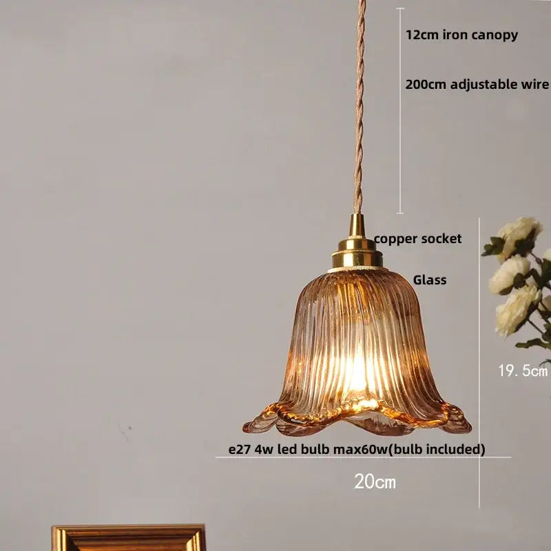 A warm amber glass adjustable pendant light with fluted bell shape and brass accents for dining room use