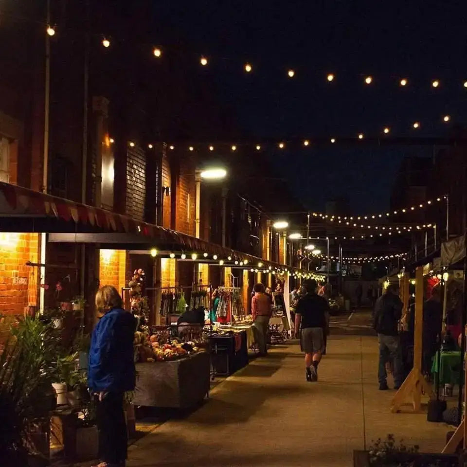 String of warm-toned vintage amber glass decorbites g40 3w led bulbs strung across an alleyway for living room decor