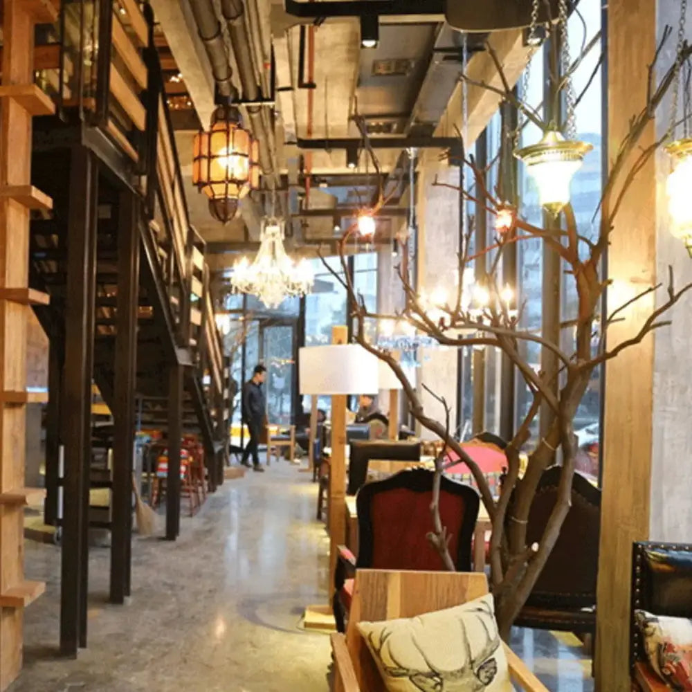 A tall slender tree-like decorative piece displayed alongside vintage amber glass led filament bulbs for dining room use