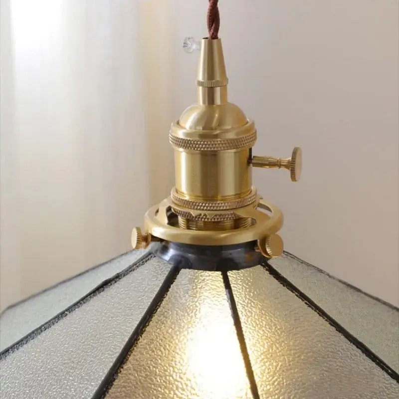 Vintage amber glass led pendant light with brass finish, textured gray glass led panels, and dark metal frame for dining room