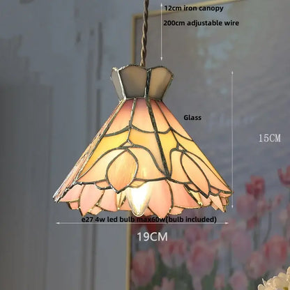 A warm-toned vintage amber glass led pendant light with floral design and dark metal framing for dining room use
