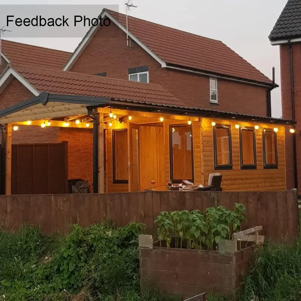 The house features warm white vintage amber glass led string lights decorbites g40 illuminating the porch