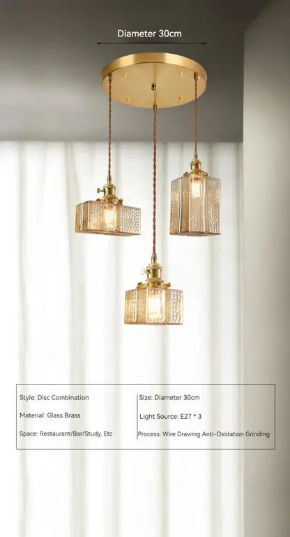 Vintage amber glass pendant light with gold-toned brass disc fixture and three textured glass pendant shades