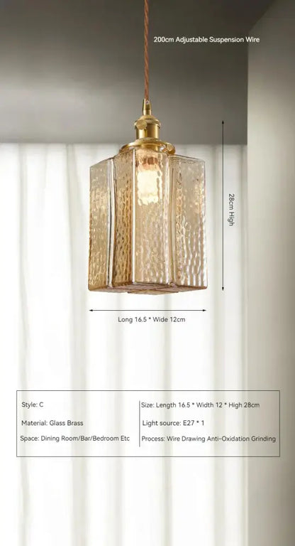Vintage amber glass pendant light with a gold-toned hammered brass finish and rectangular prism shape for dining room