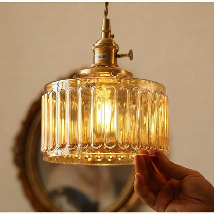 Vintage amber glass pendant light with vertical ribbed texture and brass fixture for kitchen island lighting