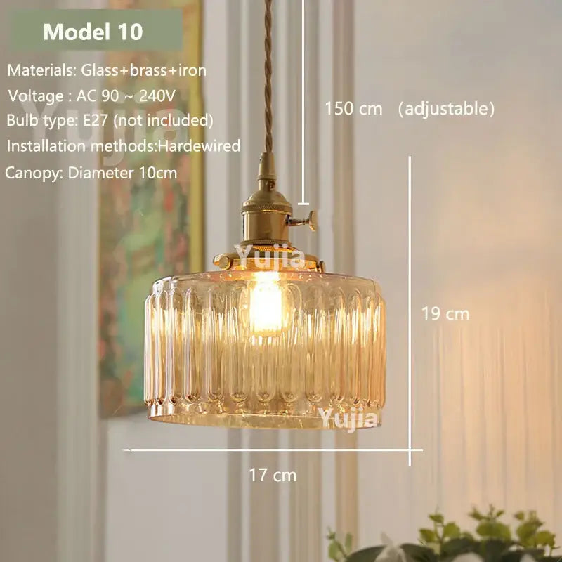 Vintage amber glass pendant light with vertical ridges and brass iron hardware hanging from twisted cord for kitchen island